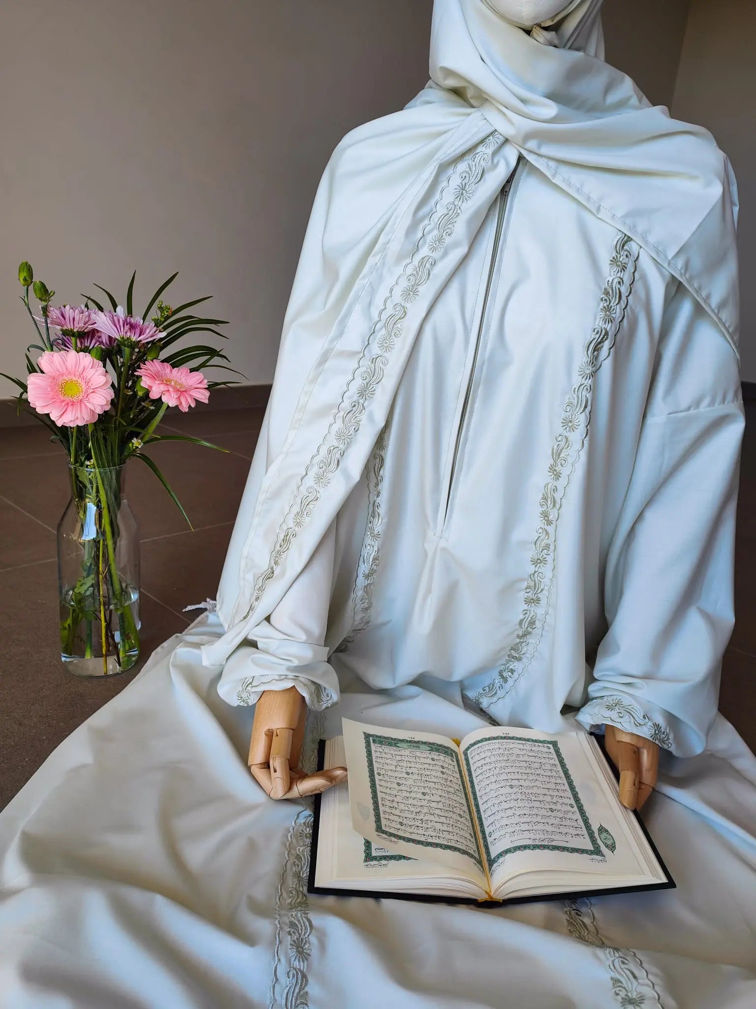 mannequin en tenue de priere avec coran dans les mains
